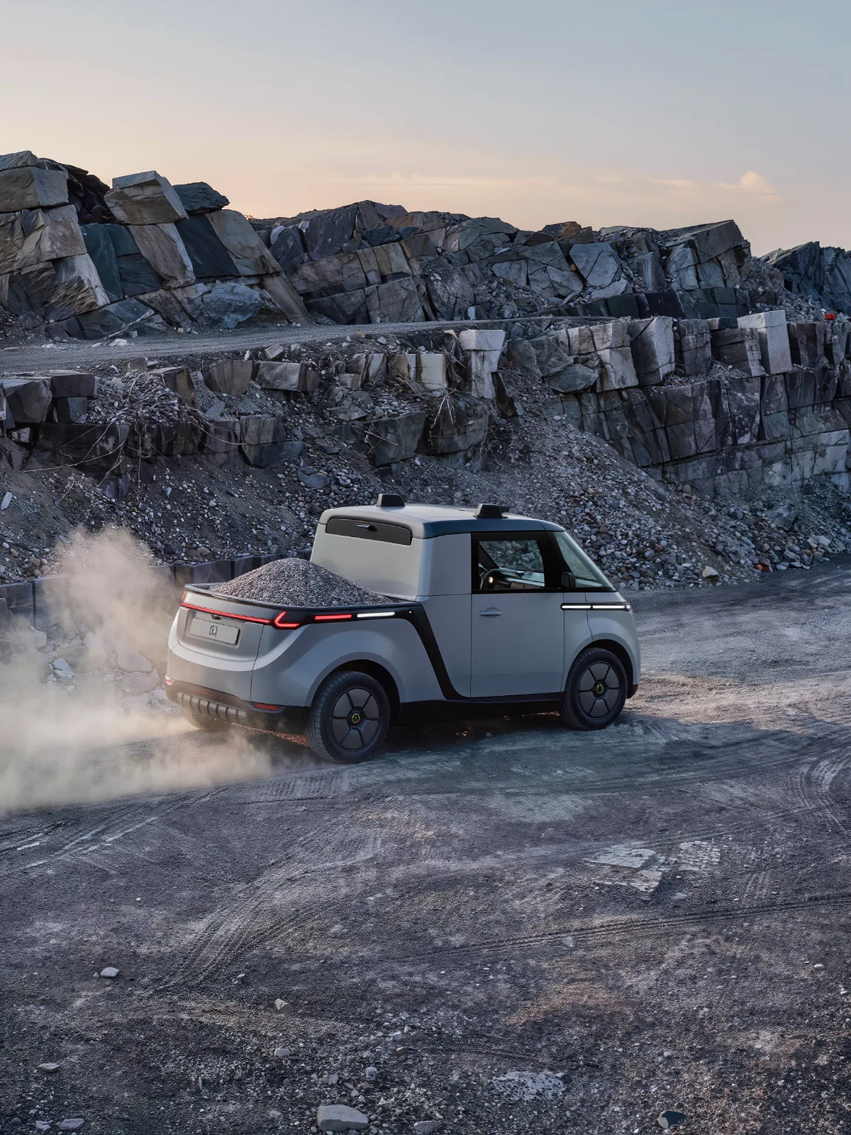 Autonomous utility vehicle hauling material on a gravel quarry road
