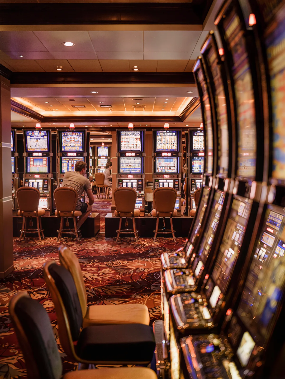 Casino slot machine aisle with a few guests playing