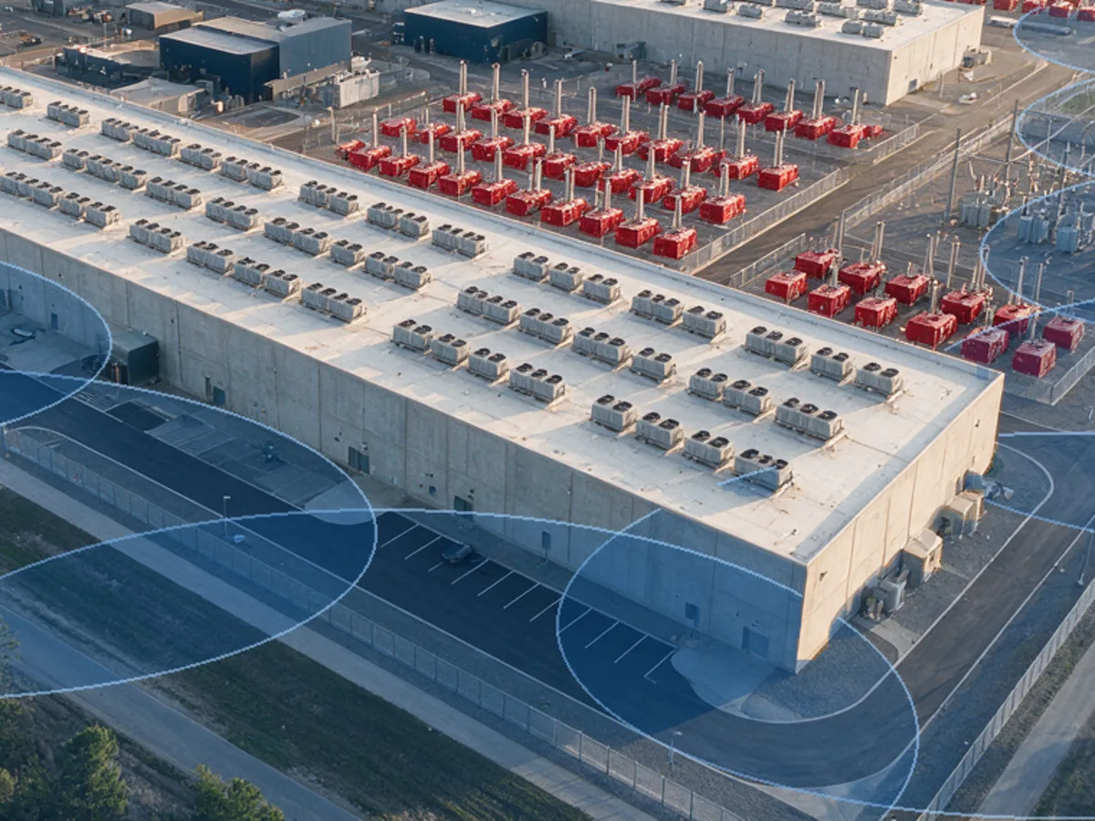 Aerial view of a data center building and perimeter fence with overlapping blue 3D LiDAR detection zones along the fence line
