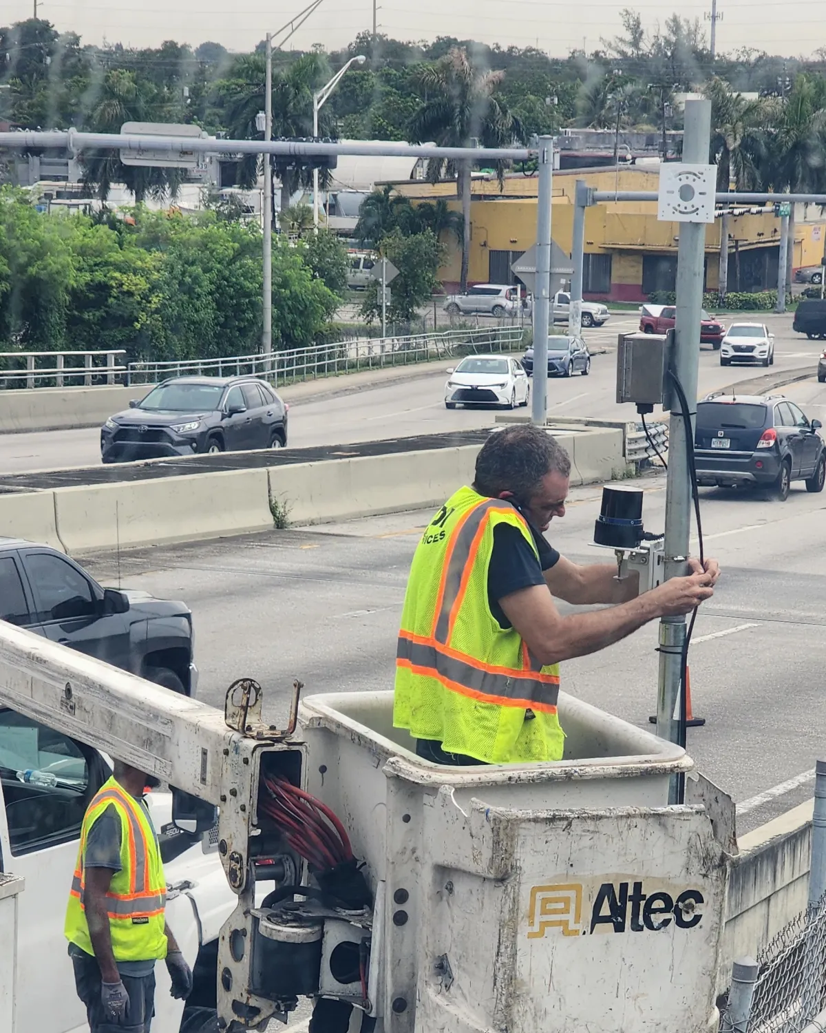 Technician in a bucket truck installing a Quanergy Q-TRACK LR 3D LiDAR sensor on a bridge pole