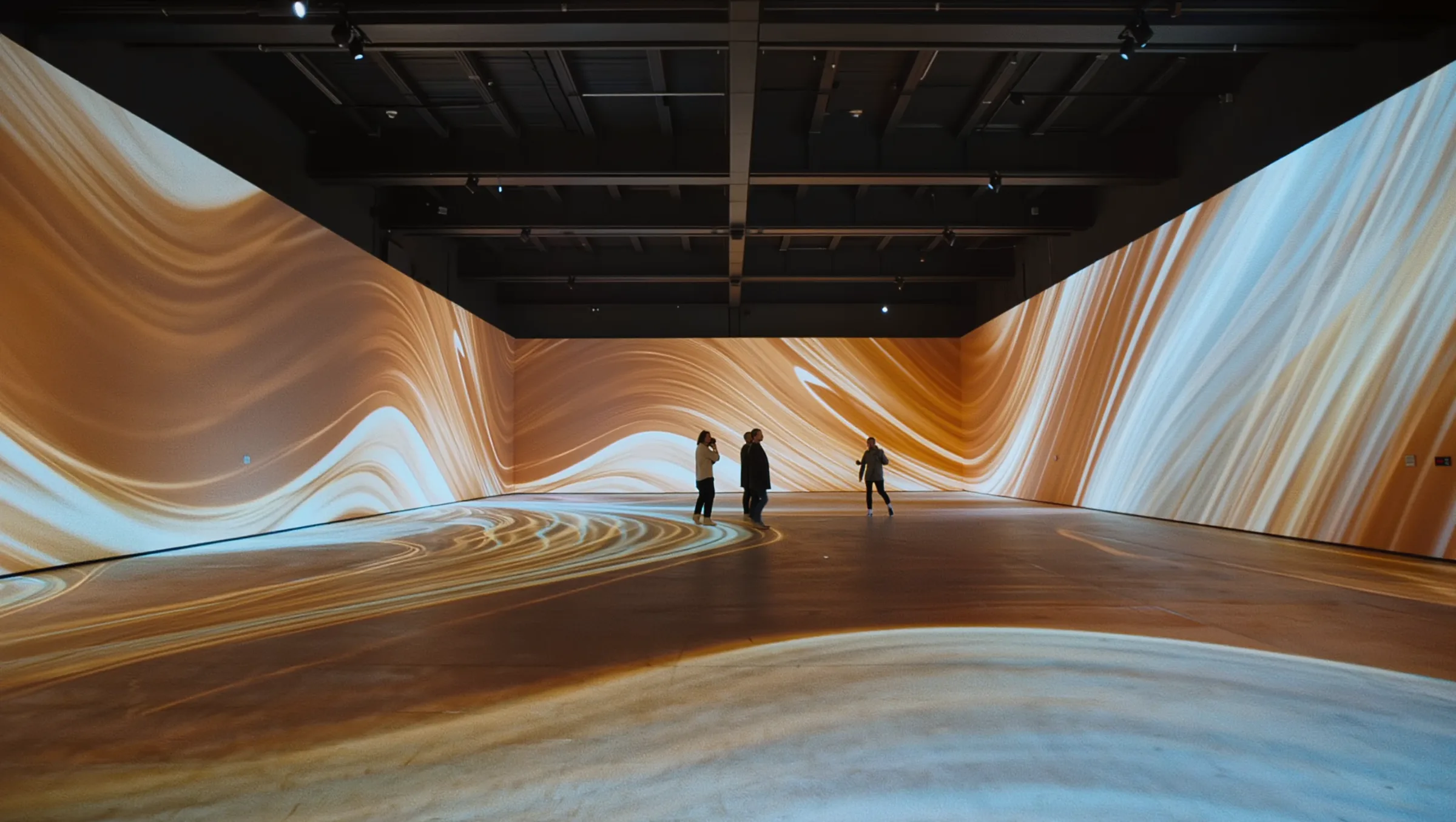 Immersive digital art room with projected light patterns around a few visitors