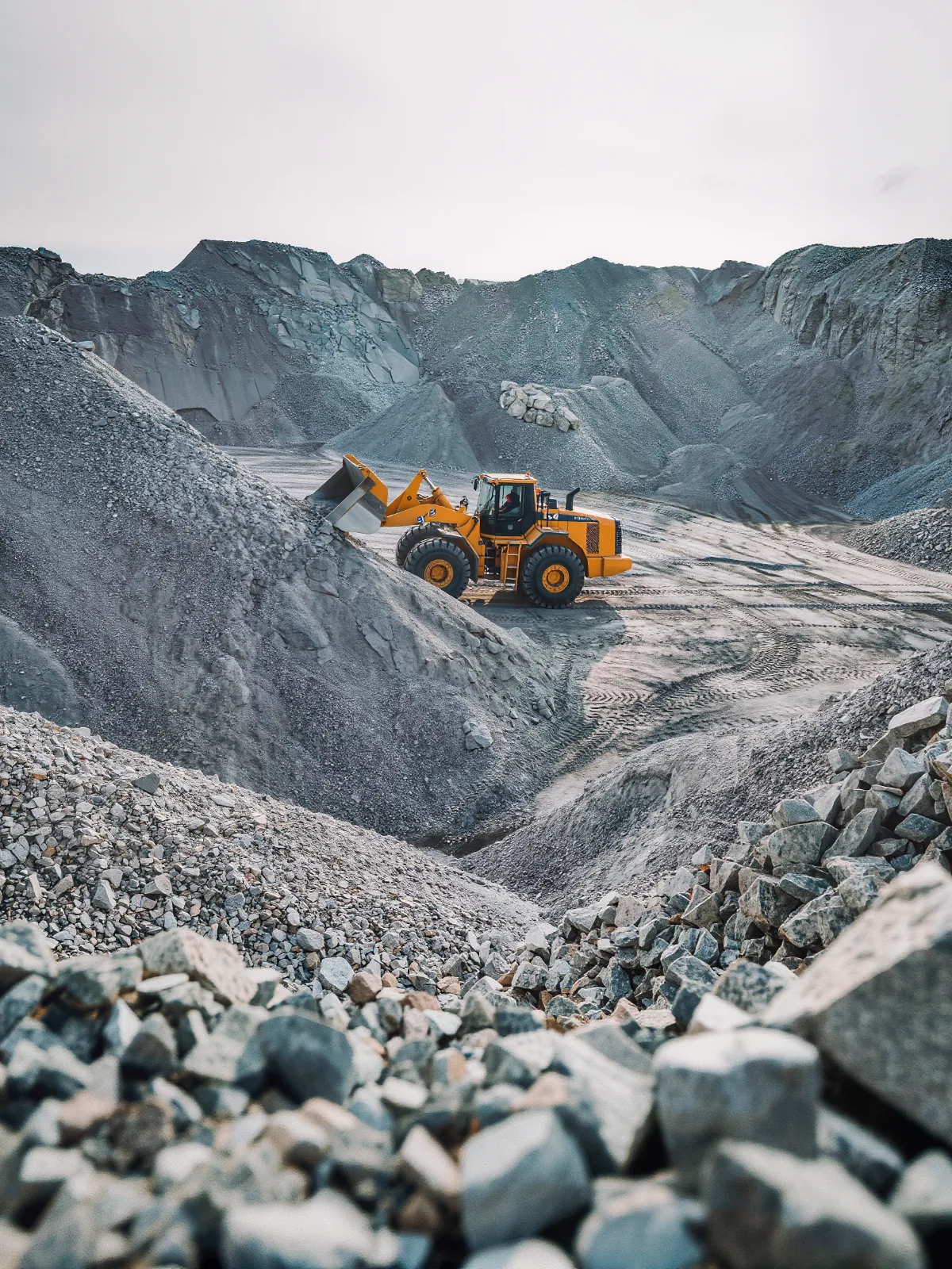 Stockpiles of crushed stone at a quarry yard with a wheel loader