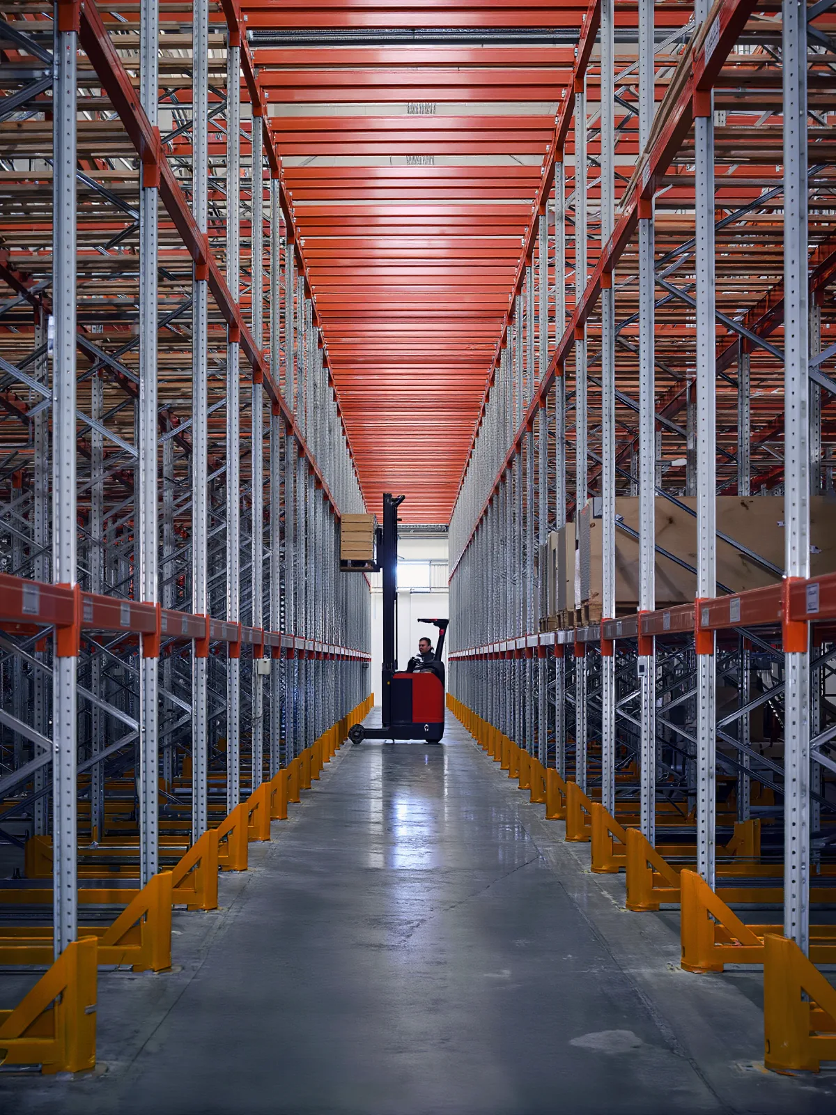 Reach truck lifting a pallet onto a high shelf in tall pallet racking
