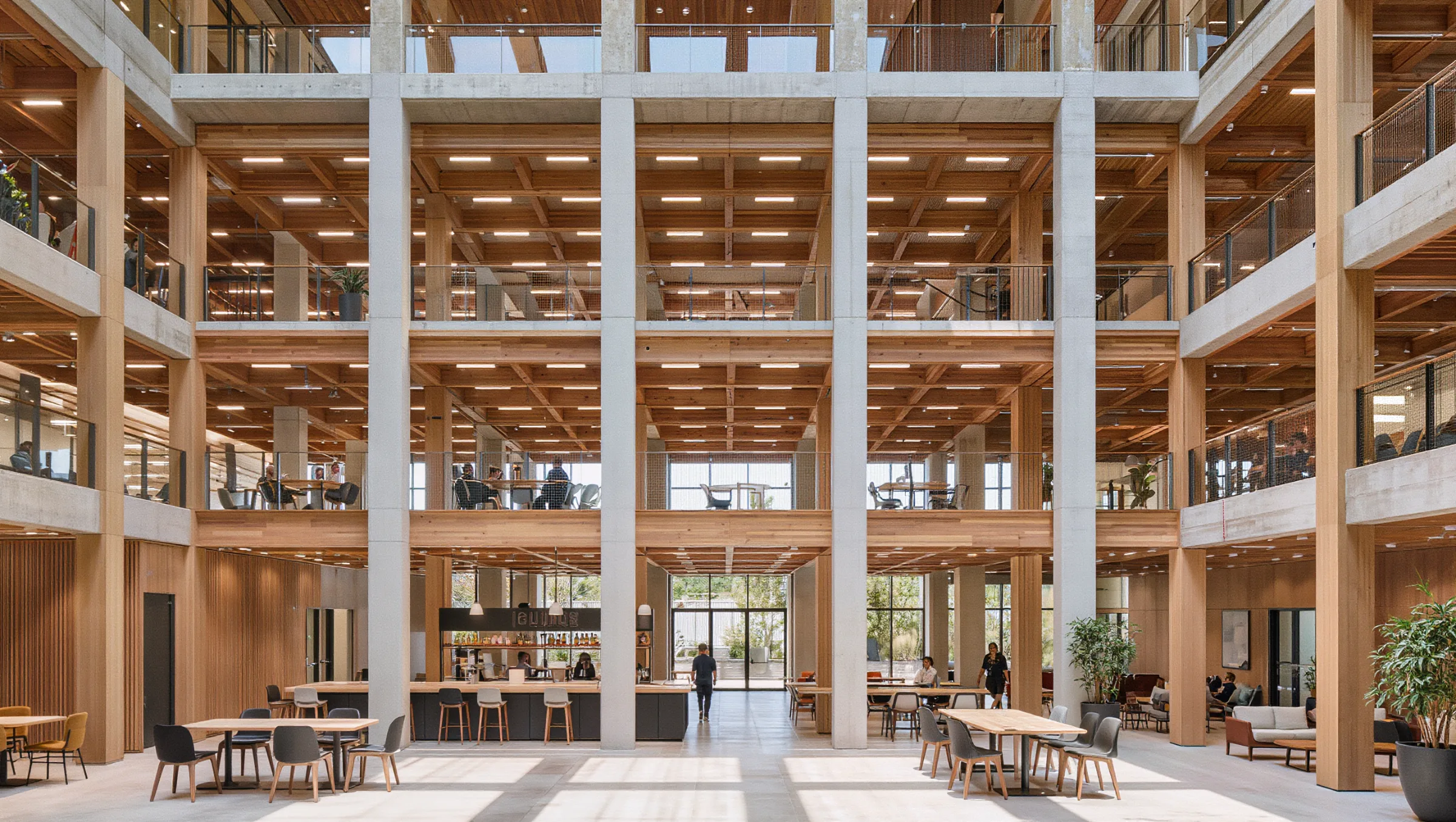 Bright multi-level office atrium with a cafe and a few employees