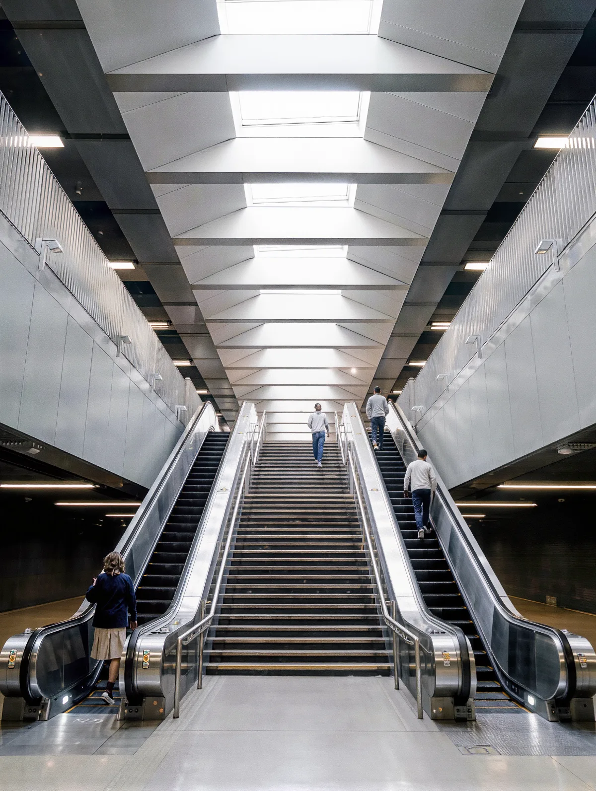 Long station escalators and stairs with a few commuters