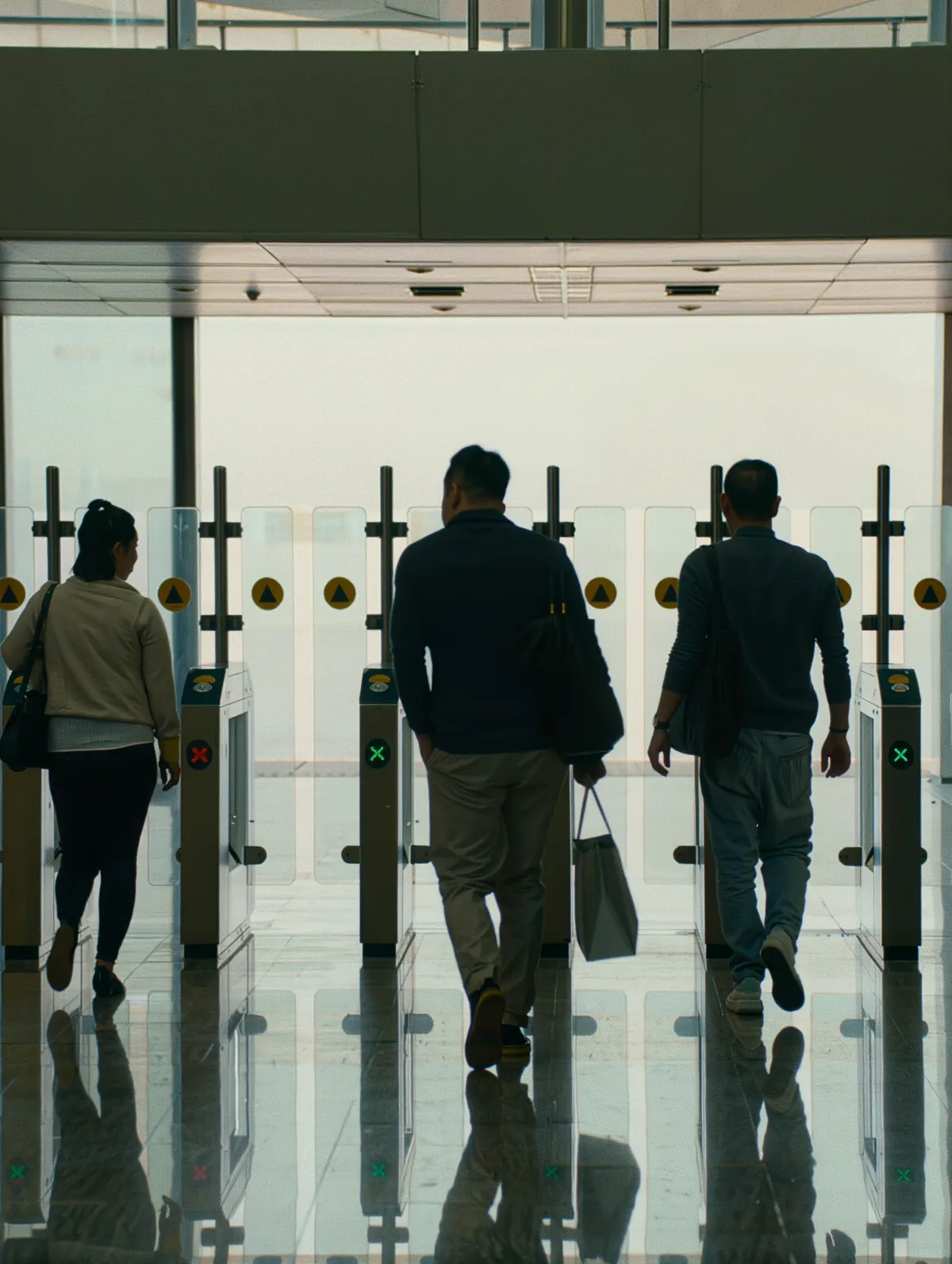 Commuters walking through modern station fare gates toward the concourse